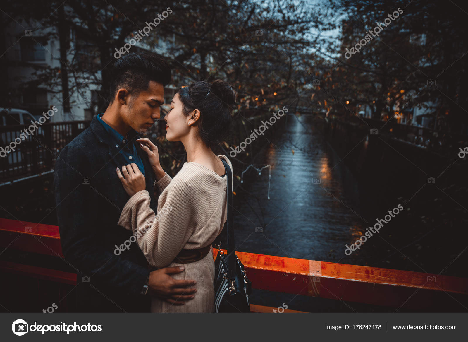 Two young men kissing, in the middle of tokio, night