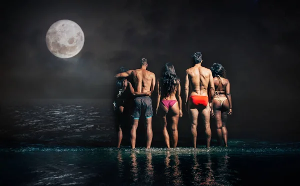Gruppo di amici che fanno il bagno notturno nell'oceano — Foto Stock