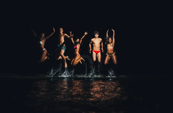 Gruppo di amici che fanno il bagno notturno nell'oceano — Foto Stock