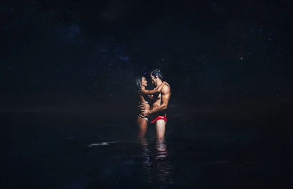 Genç çift okyanusta gece banyo sırasında öpüşme — Stok fotoğraf