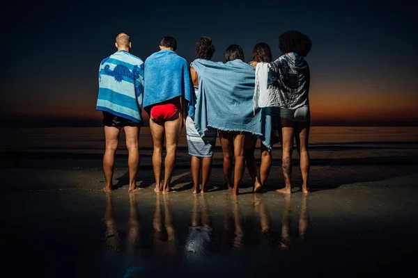 Grupo de amigos tomando un baño nocturno en el océano —  Fotos de Stock