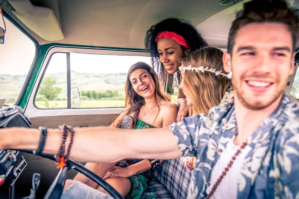 Happy friends driving a vintage minivan