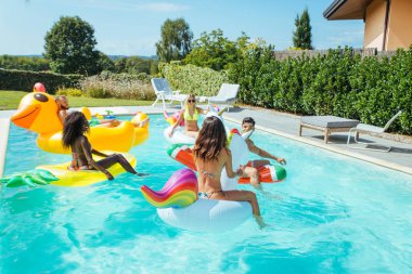 Arkadaşlar eğlenmeye bir yüzme havuzunda