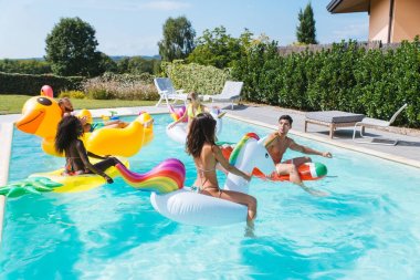 Arkadaşlar eğlenmeye bir yüzme havuzunda