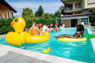 Arkadaşlar eğlenmeye bir yüzme havuzunda