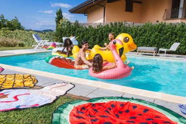 Arkadaşlar eğlenmeye bir yüzme havuzunda