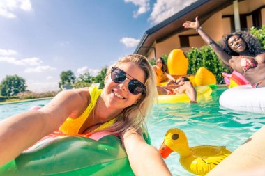 Arkadaşlar eğlenmeye bir yüzme havuzunda