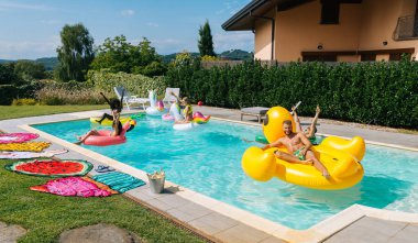 Arkadaşlar eğlenmeye bir yüzme havuzunda