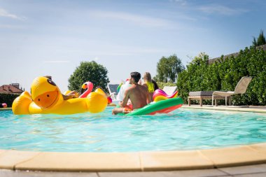 Arkadaşlar eğlenmeye bir yüzme havuzunda