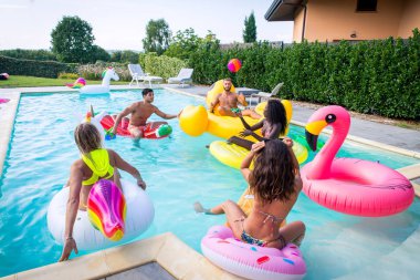 Arkadaşlar eğlenmeye bir yüzme havuzunda