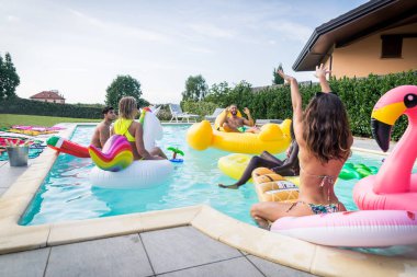 Arkadaşlar eğlenmeye bir yüzme havuzunda