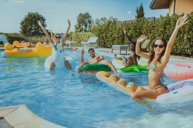 Arkadaşlar eğlenmeye bir yüzme havuzunda