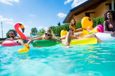 Arkadaşlar eğlenmeye bir yüzme havuzunda