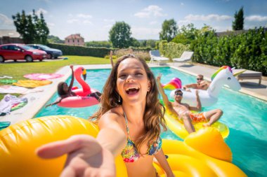 Arkadaşlar eğlenmeye bir yüzme havuzunda