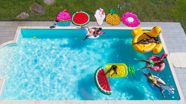 Amigos divirtiéndose en una piscina — Foto de Stock