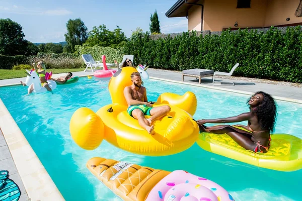 Amigos se divertindo em uma piscina — Fotografia de Stock