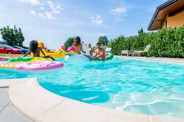 Arkadaşlar eğlenmeye bir yüzme havuzunda
