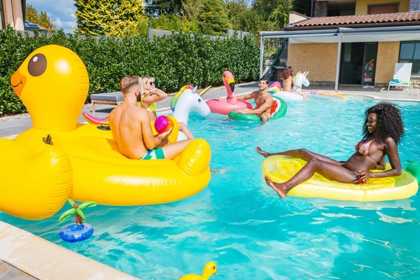 Amigos se divertindo em uma piscina — Fotografia de Stock