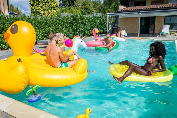 Amigos divirtiéndose en una piscina — Foto de Stock