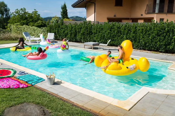 Amigos divirtiéndose en una piscina — Foto de Stock