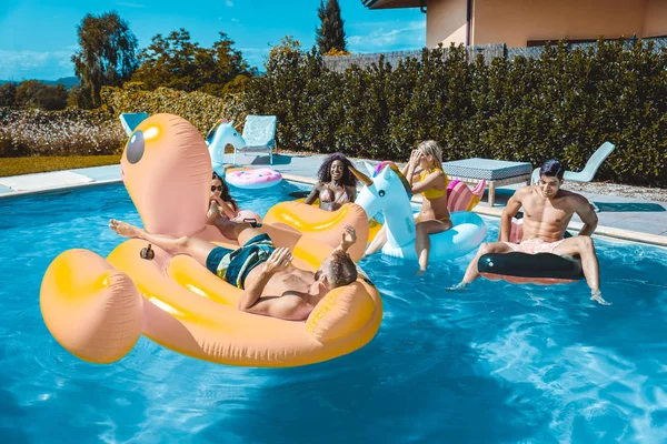 Friends having fun in a swimming pool — Stock Photo, Image