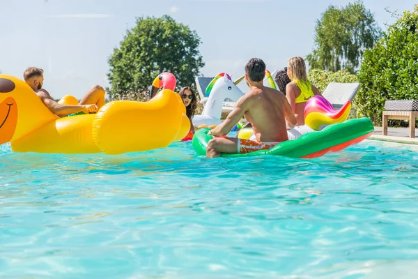 Vrienden vermaken in een zwembad — Stockfoto