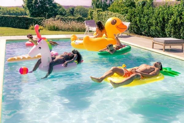 Vrienden vermaken in een zwembad — Stockfoto