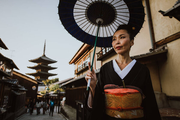 Beautiful japanese senior woman walking in the village. Typical 