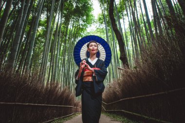 Güzel Japon kadın bambu ormanında yürüyüş kıdemli