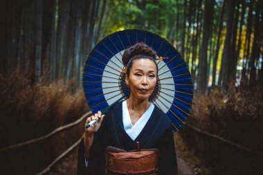 Güzel Japon kadın bambu ormanında yürüyüş kıdemli