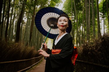 Güzel Japon kadın bambu ormanında yürüyüş kıdemli