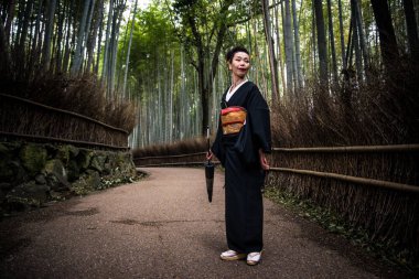 Güzel Japon kadın bambu ormanında yürüyüş kıdemli