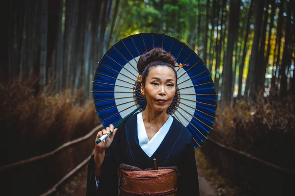 Mooie Japanse senior vrouw wandelen in het bamboebos — Stockfoto