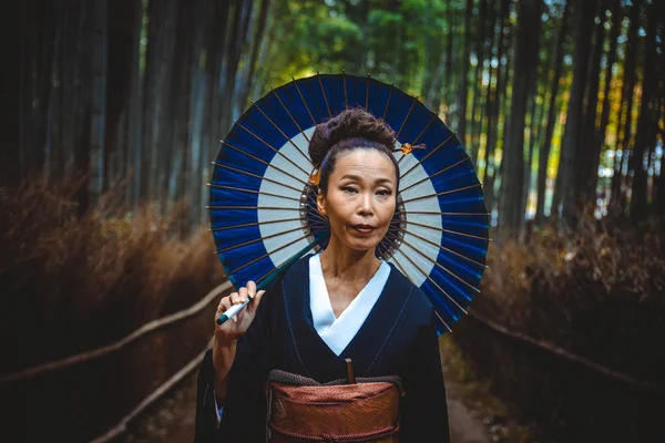 Bela japonesa sênior mulher andando na floresta de bambu — Fotografia de Stock