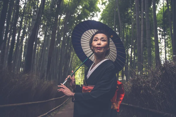 Belle femme japonaise senior marchant dans la forêt de bambous — Photo