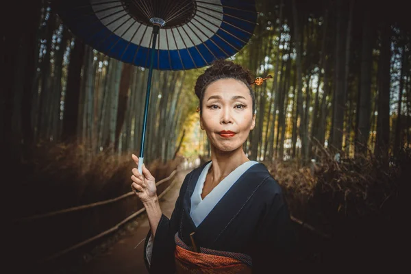 Bela japonesa sênior mulher andando na floresta de bambu — Fotografia de Stock