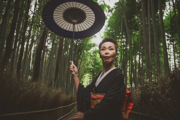 Beautiful japanese senior woman walking in the bamboo forest — Stock Photo, Image