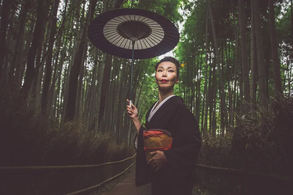 Hermosa japonesa mayor mujer caminando en el bosque de bambú — Foto de Stock