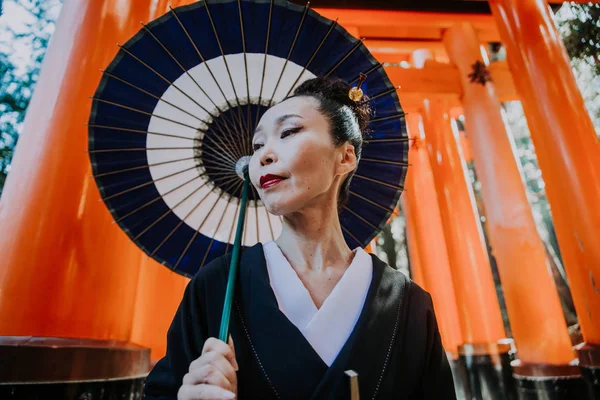 Красивая японская пожилая женщина, идущая в Fushimi inari shr — стоковое фото