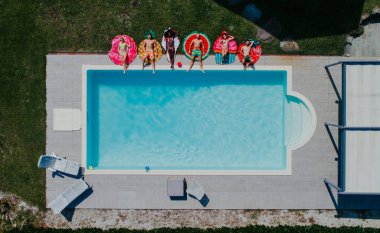 Bir grup arkadaş havuzda eğleniyor. 