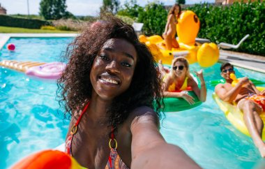 Bir grup arkadaş havuzda eğleniyor. 