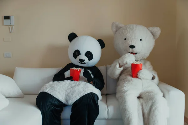 Men with animal costumes spending time inside the house