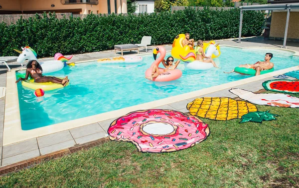 Група друзів розважаються у басейні — стокове фото