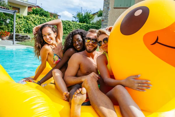 Grupo de amigos se divertindo na piscina — Fotografia de Stock