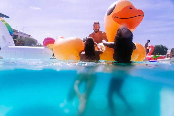 Grupo de amigos se divertindo na piscina — Fotografia de Stock