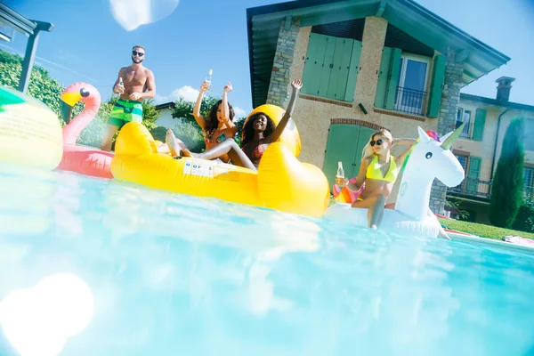 Grupo de amigos se divertindo na piscina — Fotografia de Stock