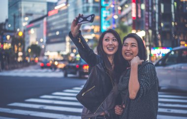 İki Japon kadınların yanında Tokyo gündüz sırasında. Shoppi yapma