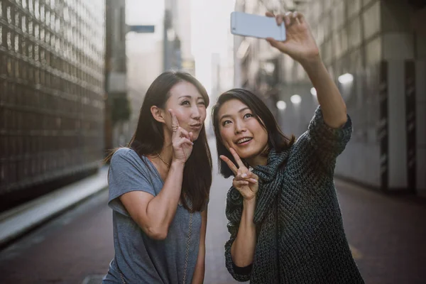 İki Japon kadınların yanında Tokyo gündüz sırasında. Shoppi yapma