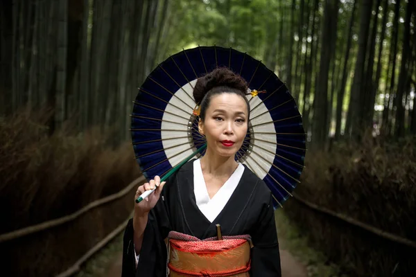 Japansk kvinna med kimono i Arashiyama bambuskog — Stockfoto