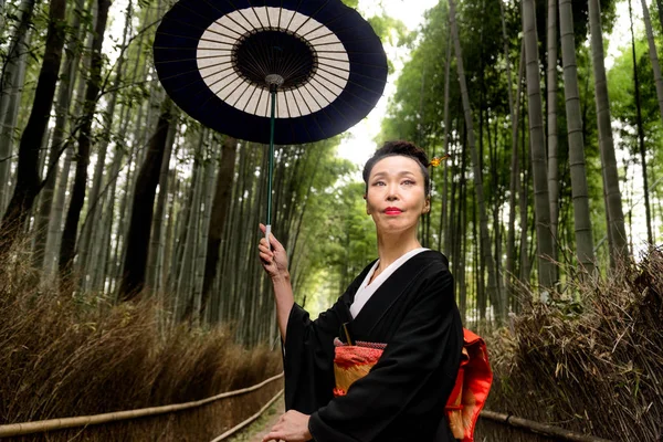 Japansk kvinna med kimono i Arashiyama bambuskog — Stockfoto